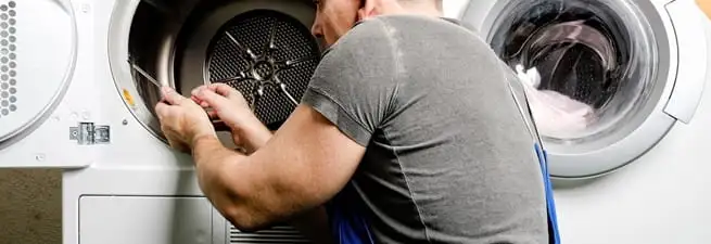Dryer repair technician fixing a clothes dryer drum in Jackson, MS