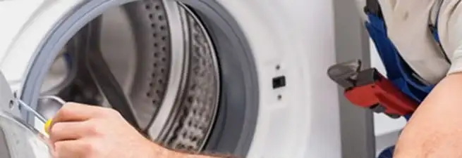Appliance technician repairing a clothes dryer drum and internal parts in Jackson, MS