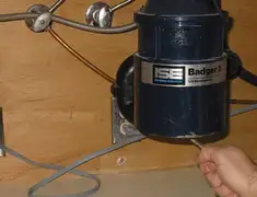 Garbage disposal repair technician tightening the mounting ring under a sink in Jackson, MS