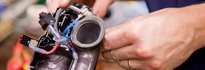 Vacuum repair technician reconnecting wiring and components in Jackson, MS