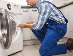 Washing machine repair technician servicing a front-load washer in Jackson, MS