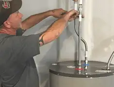 Water heater repair technician tightening supply line connections in Jackson, MS