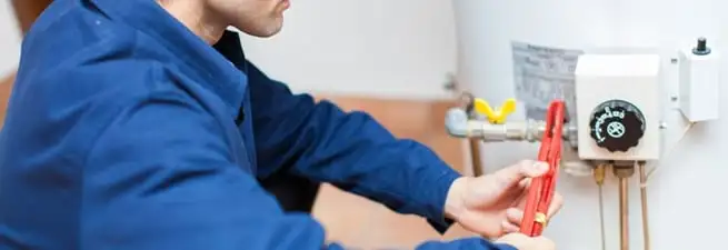 Water heater repair technician adjusting the temperature control and gas valve in Jackson, MS